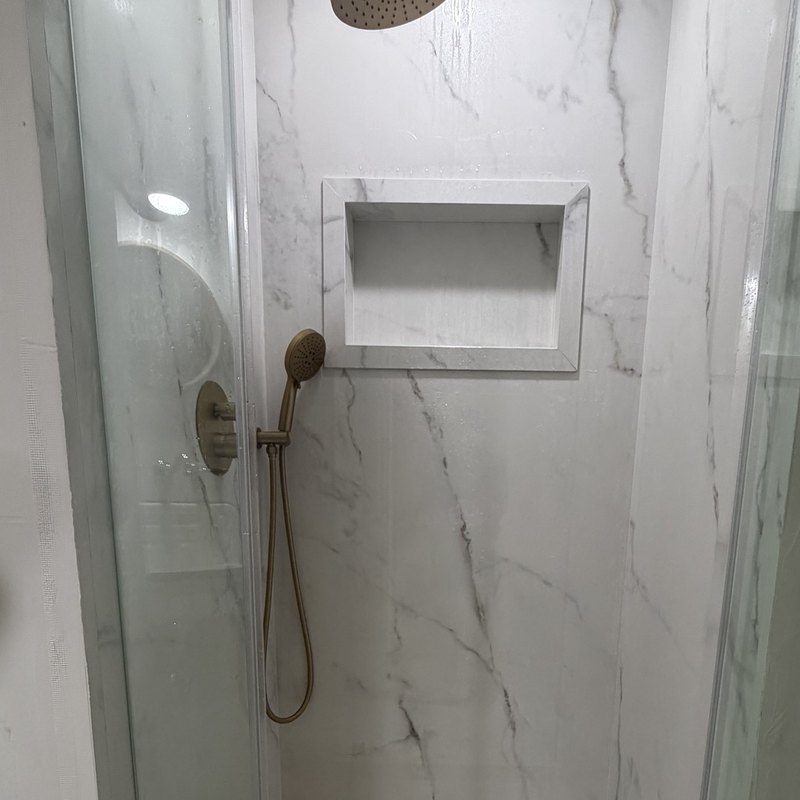 The finished porcelain shower with rain head, niche and square drain.